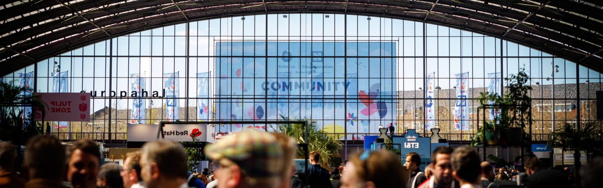 A large picture window at the entrance of an event with a sign through the window that says 'Community in Bloom.'